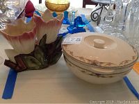 Side view of McCoy ceramic vase with floral decor and Universal Cambridge serving bowl with lid featuring floral garland and gold trim