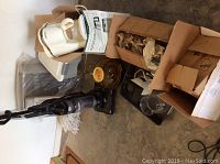 Photo showing Dirt Devil vacuum, Bioaire heater, West Bend popcorn popper, Cuisinart coffee grinder, shoe rack and boxed items