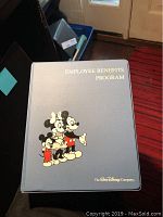 Blue Employee Benefits Program binder with Mickey Mouse family graphics and gold text