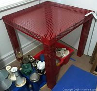 Full front view of red perforated metal table