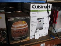 Shelf view showing Cuisinart Gourmet Collection Espresso Maker box and Homestead Pantry cookie jar box