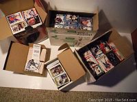 Multiple cardboard boxes filled with stacks of hockey cards, mostly standard size with various colors and photos of players.