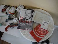 Lot shown on a surface including a hardcover 'Mr. Hockey Gordie Howe My Story' book, a signed paper, and a folded red Detroit Red Wings flag.