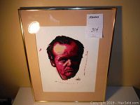 Framed watercolor print portrait of Jack Nicholson with beige mat and gold frame showing slight sticker residue on glass.