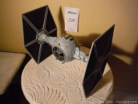 Front view of Star Wars TIE Fighter spaceship model showing attached hexagonal solar panels and spherical cockpit.