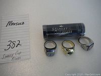 Photo showing all four rings including the mystery ring in packaging with handwritten lot number.