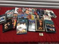 Collection of DVDs and Blu-ray discs spread on a surface, showing a variety of movie and TV series titles including sealed and unsealed items.