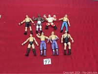 Lot of eight wrestling figures posed on a red background showing varied poses and outfits