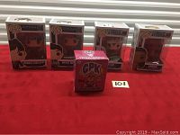 Lot overview showing four Funko Pop figures and one Garbage Pail Kids vinyl figure arranged on red surface.