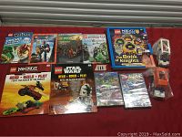 Photo of LEGO books, sealed DVDs, and LEGO City build models including garage, truck, and camper.