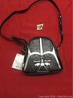 Front angled view of the Darth Vader purse showing design and attached tags on red background