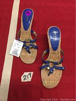 View showing full pair of women's sandals on red background, displaying overall design.