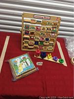 Vintage 1985 wooden learning board with rotating alphabet and number blocks, a wooden shape sorting and stacking toy with colorful pegs, and a wooden animal and shape puzzle box.