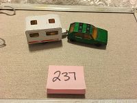 Green Matchbox VW Golf 1976 with white caravan side view on beige surface with pink lot number note.