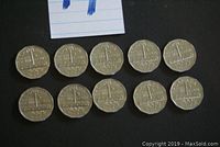 Top view of ten circulated Canadian nickels showing reverse sides with denomination and commemorative date 1751-1951.