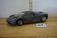 Side view of dark gray 1993 McLaren F1 model car showing profile and missing passenger side mirror