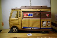 Side view of the Big Jim camper toy showing closed fabric panel with logos and decals