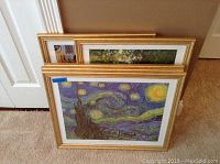 Stack of five framed prints leaning against the door showing gold frames and the front print of Van Gogh's Starry Night with a 17.5x22 sticker.