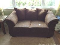 Front view of brown Ashley love seat showing fabric upholstery and cushions