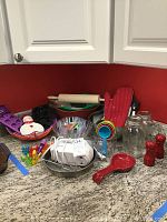 View of the entire lot on a kitchen countertop, showing rolling pin, measuring cups, ice cube molds, mixing bowls, mixer, and other items