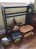 Photo showing the wooden blanket stand, star wall art, stool, tissue dispenser, lidded box, and square decorative box grouped for country home decor.