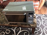 Front and side view of Samsung silver microwave oven showing control panel and door