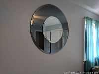 Mirror wall-mounted showing two-tone design with darker frosted outer edge and clear center.
