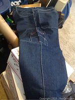 Folded dark blue Phat Farm jeans with visible stitching and back pocket