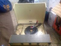 Vintage Emerson record player with lid open, showing inside with turntable and tonearm visible