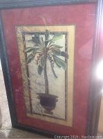 Full front view of framed large decorative painting depicting a potted tropical plant with broad leaves and red berries, set against a textured neutral background.