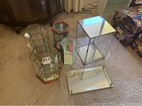 Photo of all display cases and mirrored tray grouped on floor, showing variety in shape and size
