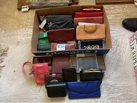 Overhead image showing a large number of wallets in various sizes laid out in a box and on a surface, highlighting color and size variety.