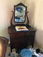 Full view of vintage wooden dresser with beveled mirror and U.S. Army pillow on top.