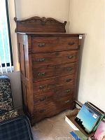 Front and side view of wooden high dresser showing six drawers, carved top backboard, and ornate drawer handles.
