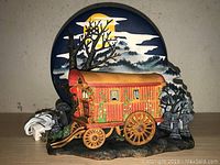 Lamp shown unlit with full detail of wagon and night sky background with moon and trees.