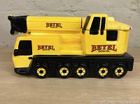 Side view of the ceramic cookie jar shaped like a construction crane showing Beyel Bros. logos and wheels.