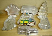 Photo of Wilton aluminum cake pans showing crown, van, Christmas tree, dinosaur, farm tractor, and 3D car designs.