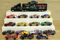 Full overview of 16 die cast racing cars and tractor trailer showing color and number variety