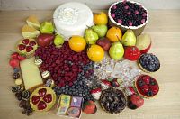 Full assortment of faux food props including cakes, fruits, berries, candies, and ice cubes displayed on tabletop.