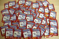 Image showing 50 unopened Panini hockey sticker packs laid out, each pack with the same red packaging from the 1994-95 collection.