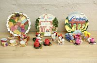 Full view of three miniature tea sets displayed with their respective decorative plates. Themes include Dalmatian firemen, locomotives, and bears.