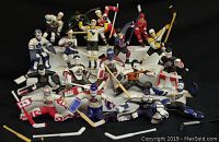 Photo showing 18 loose Starting Lineup hockey figures from late 1990s in various team uniforms and poses