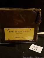 Closed brown sheet set package with label showing '1500 Thread Count Sheet Set Queen Size'.