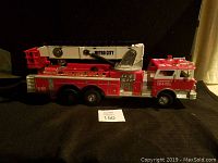 Side view of red Metro City toy fire truck showing full length and ladder