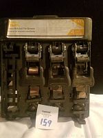 Photo showing front of the plastic carrying case containing four camo ratchet tie-down straps with label describing 16 ft length, four pack, and heavy duty steel hooks.