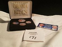 Photo of four Obama Biden coins in a black display case with gold lettering on the lid.