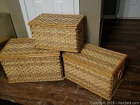 Three large rectangular wicker baskets stacked, showing woven rattan pattern and rectangular shape.