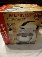 Box front showing Sunbeam Mixmaster Heritage Series 350 watt stand mixer with stainless steel mixing bowl and key features.