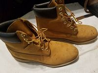 Side profile of tan leather Timberland boots showing size 11.5 and wear marks on toe area.