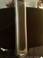 Full front view of the silver LASKO tower heater showing vertical grille and base with LASKO branding.